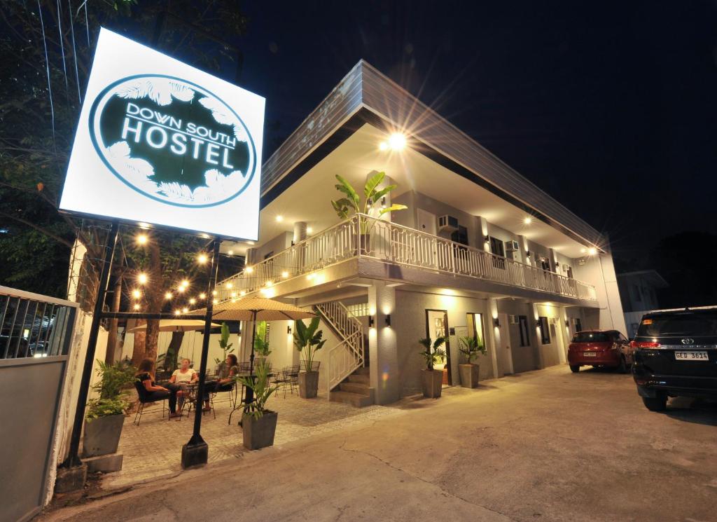 ein Hotel mit einem Schild davor in der Nacht in der Unterkunft Down South Hostel in Cebu City
