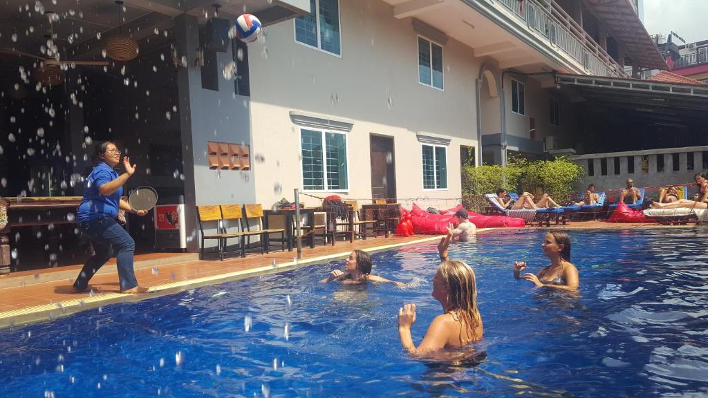 a group of people playing volleyball in a swimming pool at Siem Reap Pub Hostel in Siem Reap