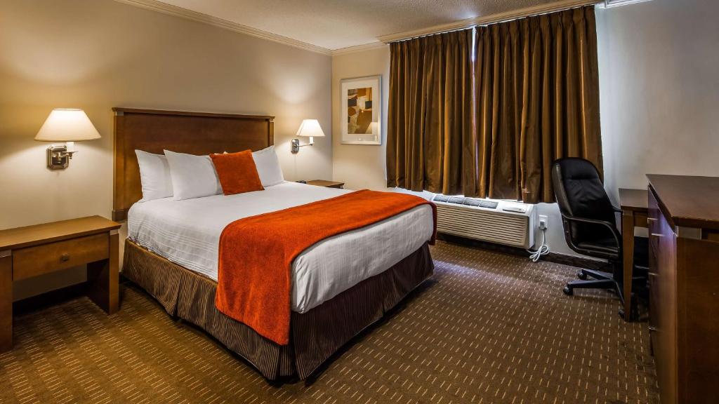 a hotel room with a bed and a desk at Best Western Plus Guildwood Inn in Sarnia