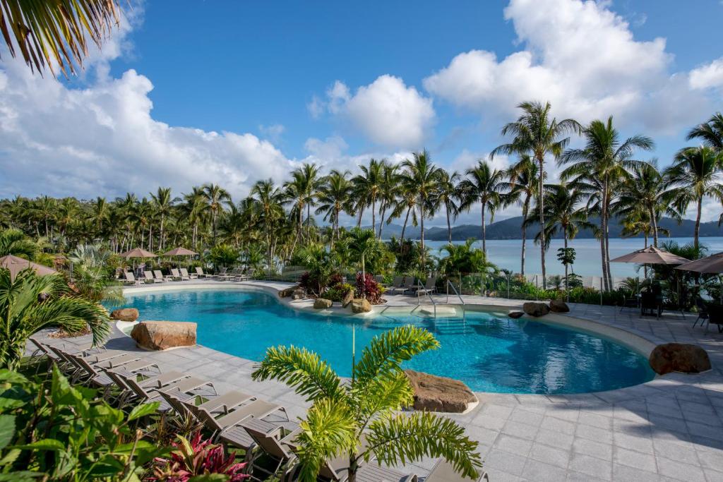 een zwembad in het resort met palmbomen bij Whitsunday Apartments in Hamilton Island