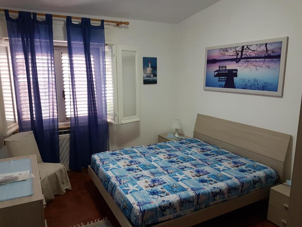 a bedroom with a bed and a picture on the wall at Appartamento centralissimo a Tortolì! 75mq in Tortolì