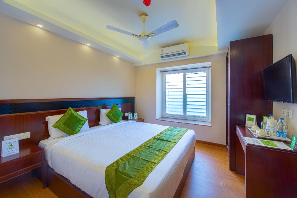 a bedroom with a large bed and a window at Treebo Trend Vedanta in Kolkata