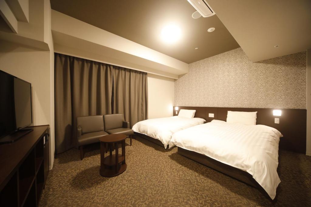 Postel nebo postele na pokoji v ubytování Dormy Inn Premium Osaka Kitahama