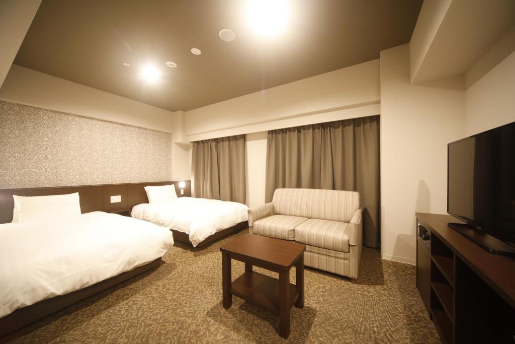 Postel nebo postele na pokoji v ubytování Dormy Inn Premium Osaka Kitahama