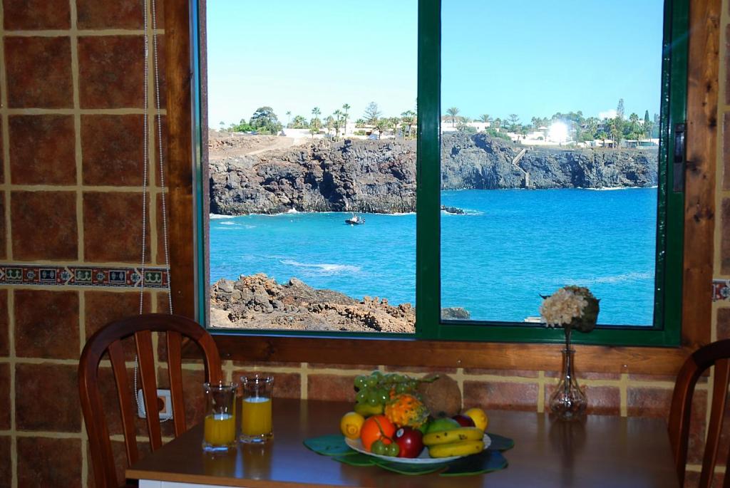 uma mesa com um prato de frutas em frente a uma janela em Sea view 6 people optical fiber em Las Galletas