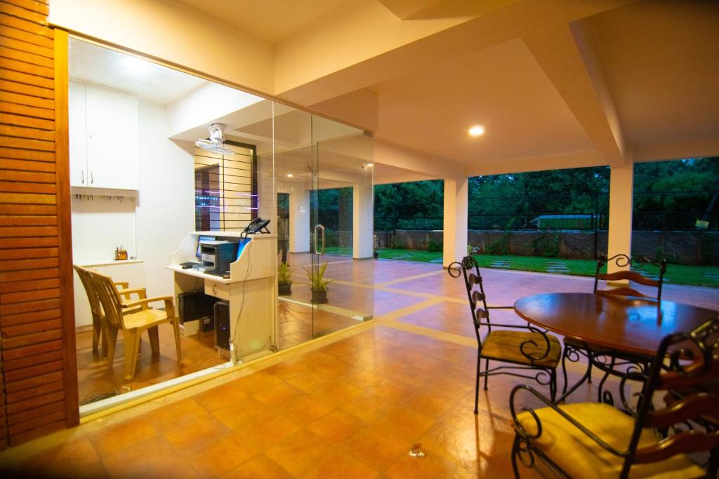 een woonkamer met een bureau en een tafel en stoelen bij Stay@ in Bangalore