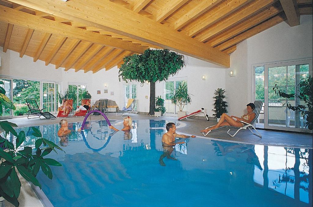 Hotel Ursula Garni في باد بروكيناو: مجموعة من الناس يلعبون في حمام السباحة