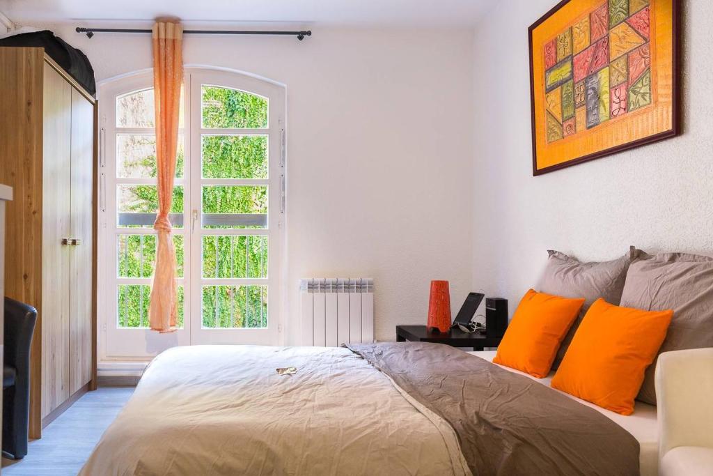 コルマールにあるTravel Homes - The Pfeffel, 2m walk Little Veniceのベッドルーム1室(オレンジ色の枕と窓付)