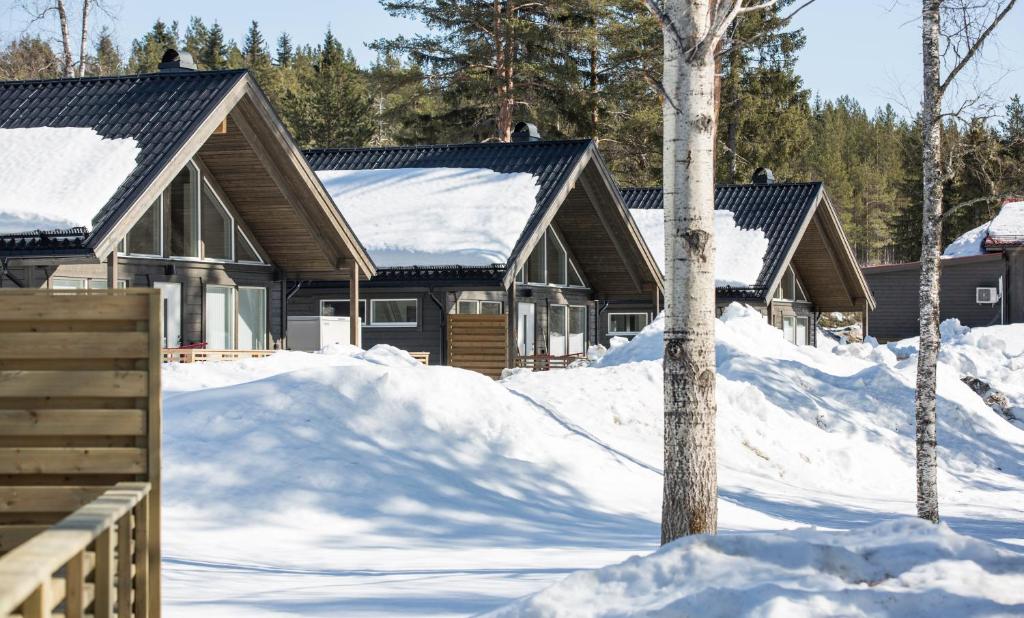 uma fila de casas cobertas de neve em Överkalix Jockfall Holiday Home em Jock