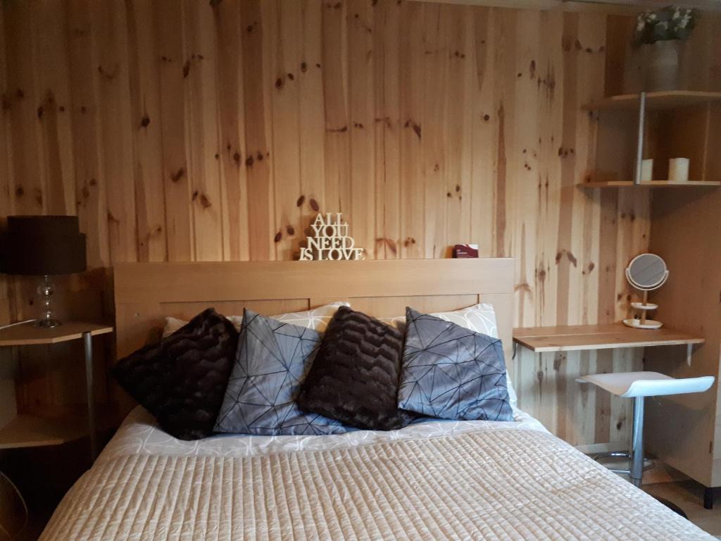 a bedroom with a bed with a wooden wall at Garden Studio Cottage in London