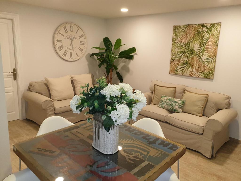 a living room with a vase of flowers on a table at A&S Apartamentos Malaga in Málaga