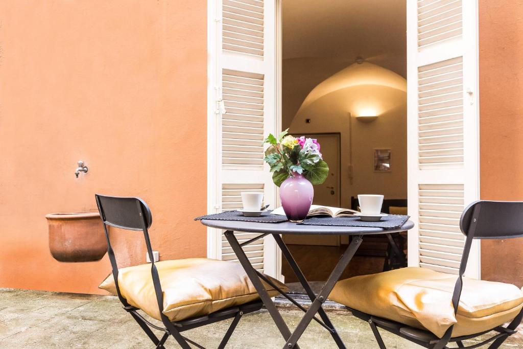 a table with two chairs and a vase with flowers at Lovely New Home, Via Nazionale in Rome