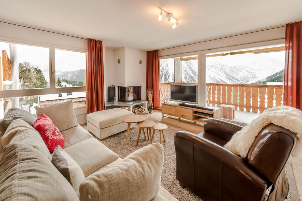 ein Wohnzimmer mit einem Sofa und einem TV in der Unterkunft Amselfluh in Arosa