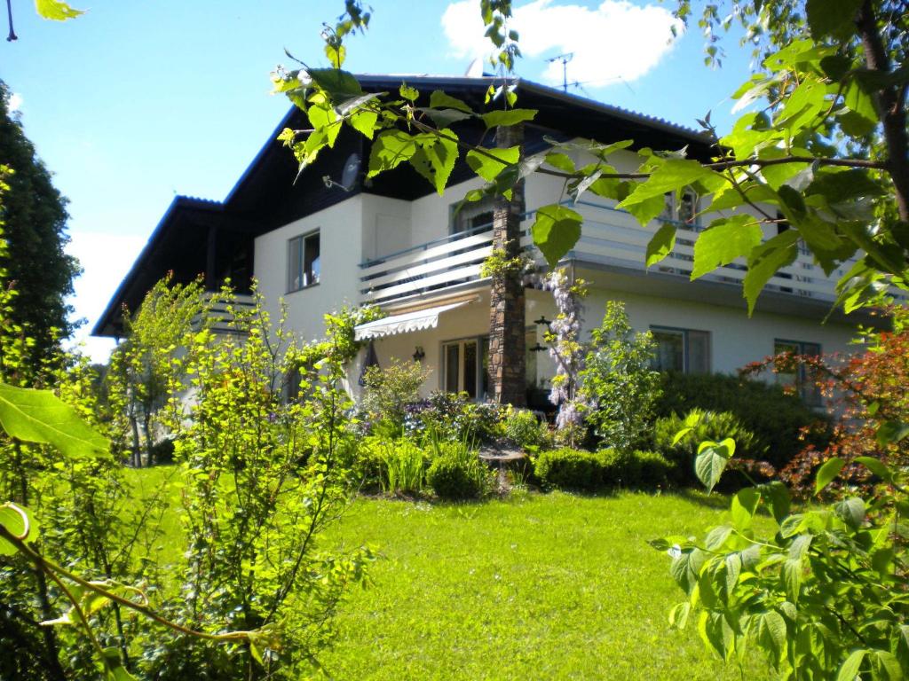 a garden in front of a white house at Gästezimmer Weiss in Maria Taferl