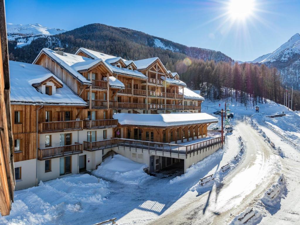 a ski lodge in the mountains with snow at SUNWEB Résidence Les Balcons & Chalets de Bois Méan in Les Orres