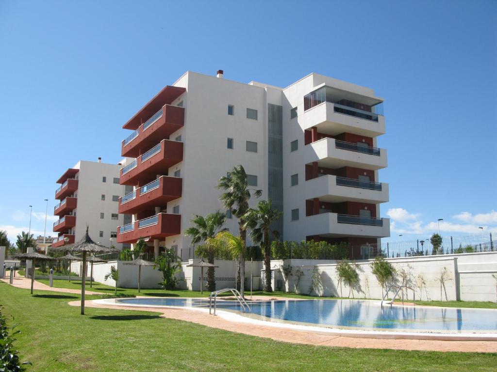 um edifício e uma piscina em frente a um edifício em Arenales Playa by Mar Holidays em Arenales del Sol