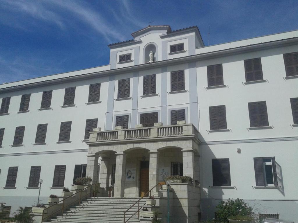 a large white building with stairs in front of it at Ostello Villa Monte Mario in Rome