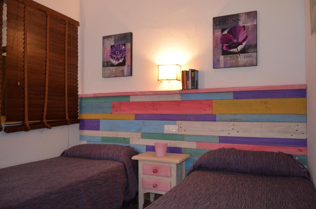 コニル・デ・ラ・フロンテーラにあるEl Patio Iのベッド2台が備わるカラフルな壁の客室です。