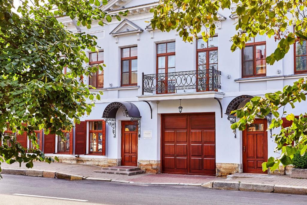 biały budynek z brązowymi drzwiami i oknami w obiekcie Alexander House w Petersburgu