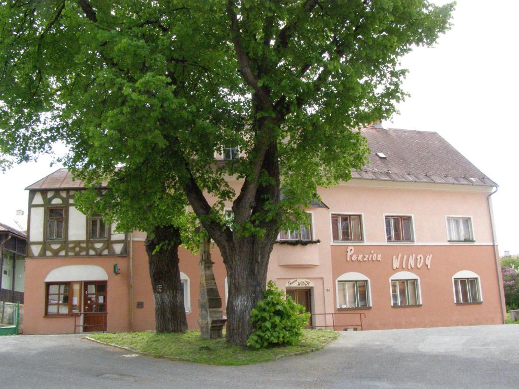 ein großes Gebäude mit einem Baum davor in der Unterkunft Apartmány Windy in Staré Město