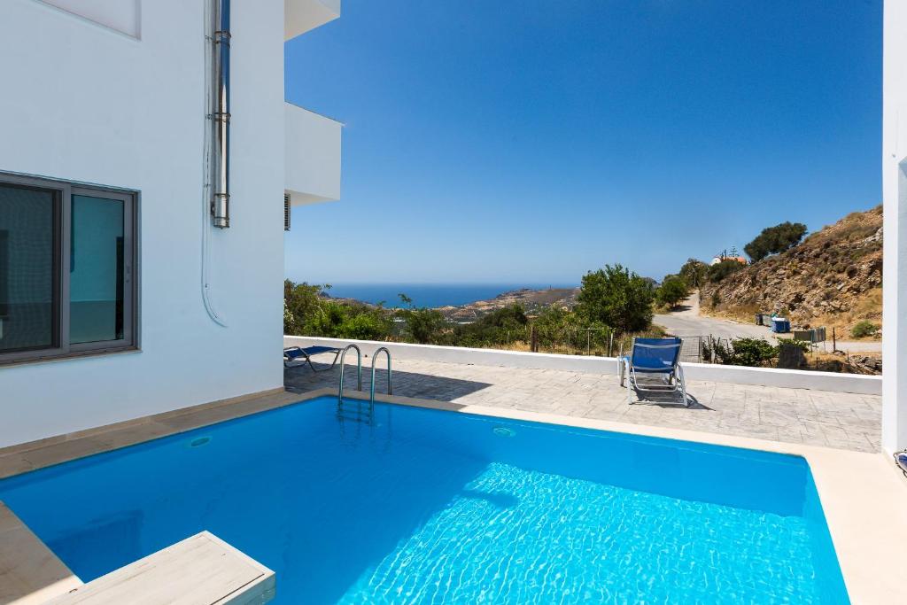 a pool with a view of the ocean from a house at Sunset Maisonettes in Plakias