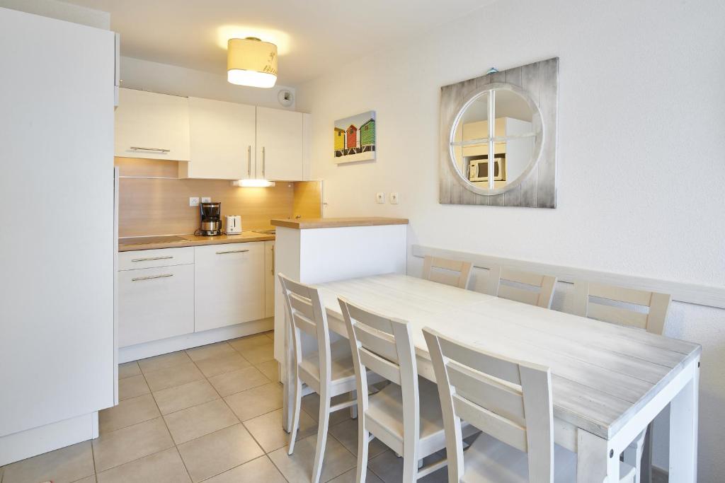 a kitchen and dining room with a table and chairs at Résidence Vacances Bleues Les Jardins d'Arvor in Bénodet
