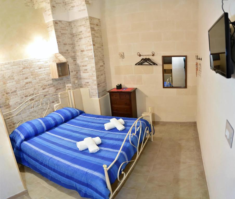 アヴェトラーナにあるCala del Conte b&bのベッドルーム1室(青いベッド1台、白いタオル2枚付)
