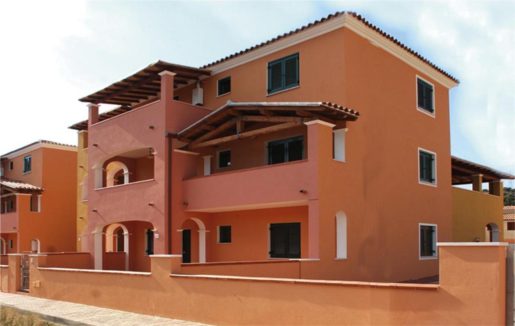 un edificio de color naranja y amarillo en Appartamenti Le Ginestre e Gli Oleandri, en Cala Liberotto