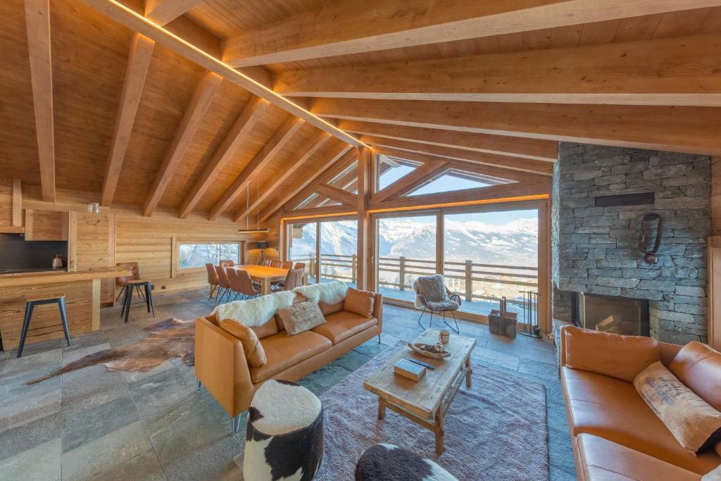 a living room with a couch and a fireplace at Oak Tree Chalet - on the ski slope - luxury! in Nendaz