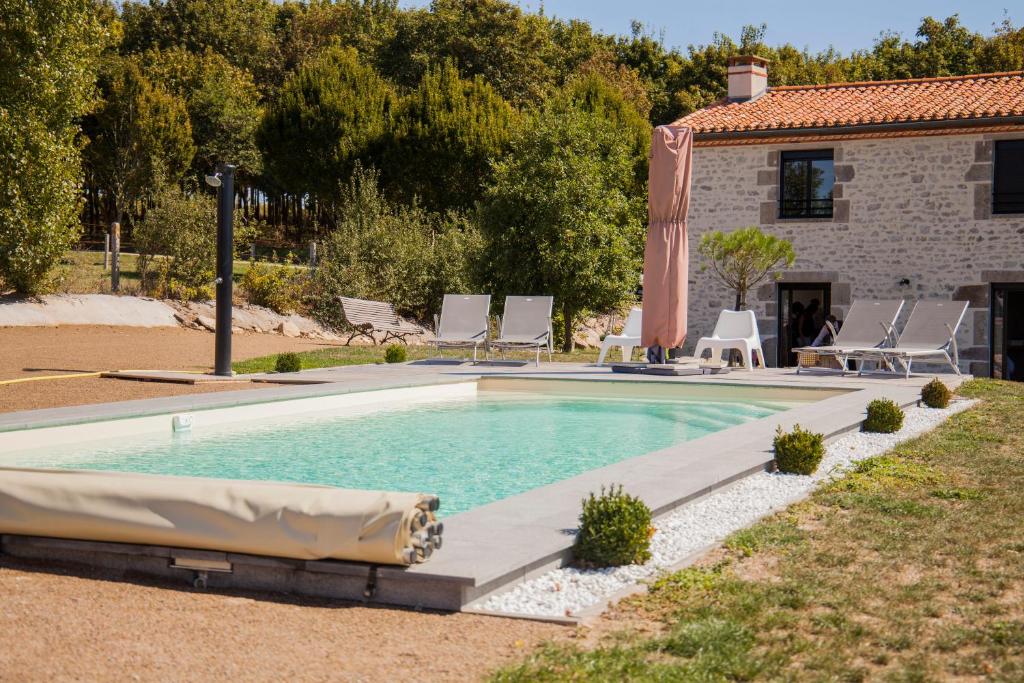 Mortagne-sur-SèvreにあるGîte "La Grange" 5 personnes proche du Puy du Fou avec piscineの家の前のスイミングプール