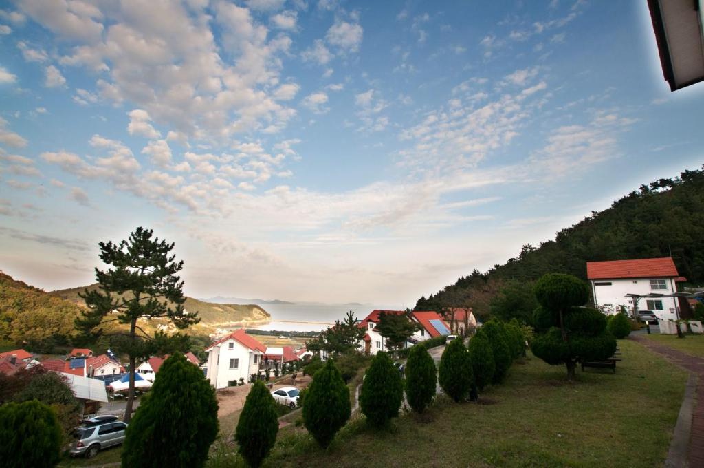 a small town with trees and houses on a hill at Namhea German Village Beethoven House in Namhae