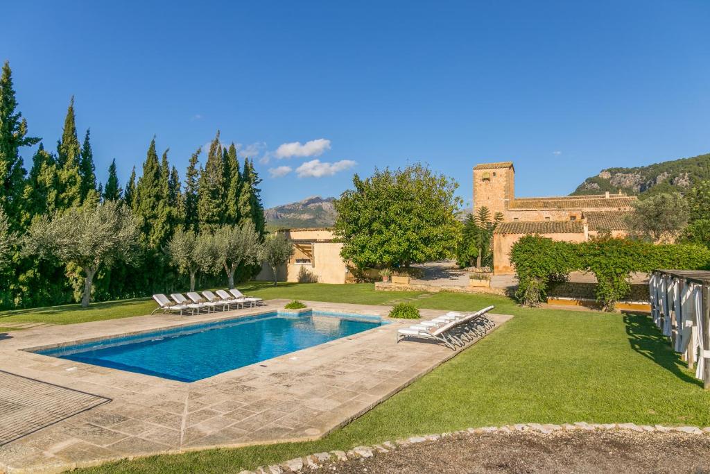 a backyard with a swimming pool and a house at Historic House in Mallorca Up To 12 Guests in Andratx