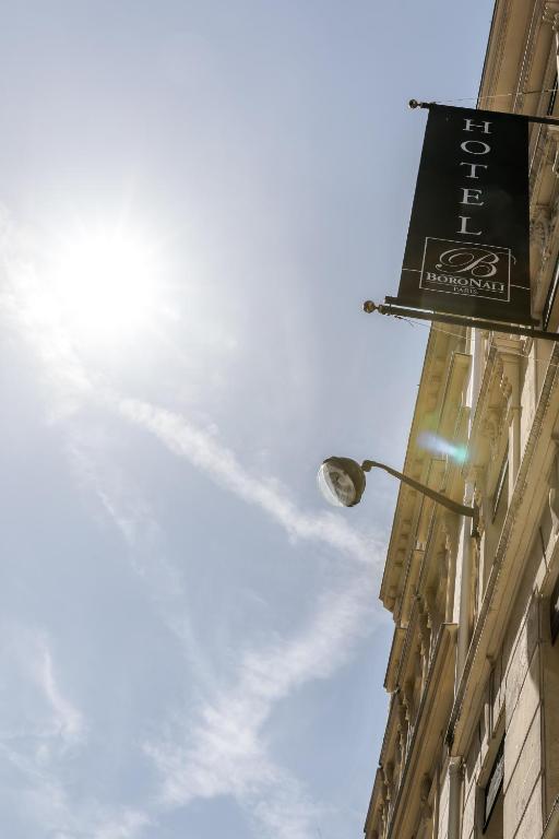 a street light with a sign on the side of a building at Hotel Boronali in Paris