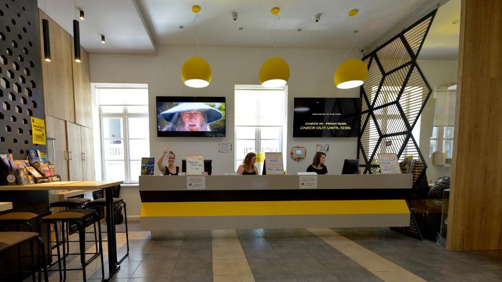 a restaurant with a counter with a tv on the wall at The Hive Party Hostel Budapest in Budapest