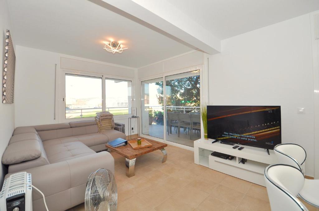 uma sala de estar com um sofá e uma televisão de ecrã plano em Appartement Station em Lloret de Mar