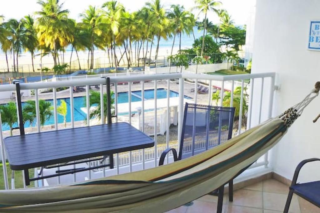 een hangmat op een balkon met een tafel en stoelen bij Lullaby of the Sea in San Juan
