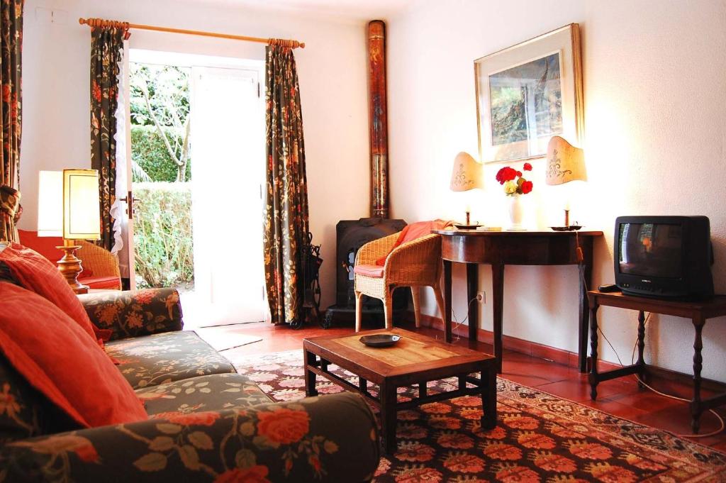 uma sala de estar com um sofá e uma televisão em Casa de Esteiro em Caminha