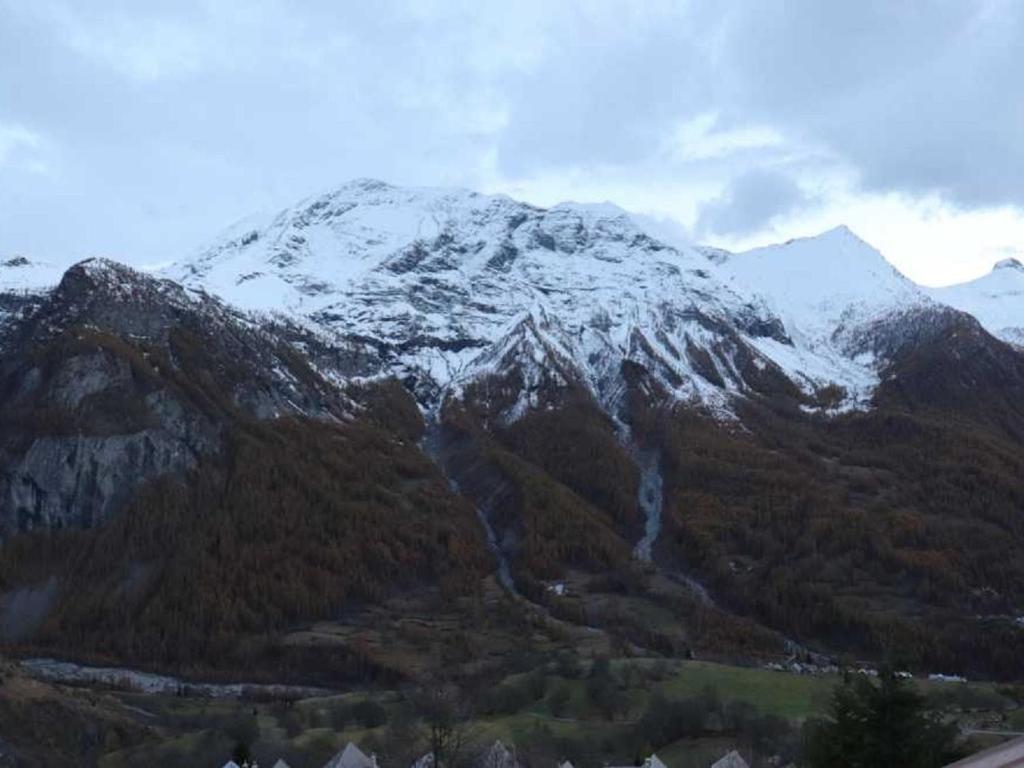 a snow covered mountain with trees in front of it at Appartement Les Chaumettes in Orcières