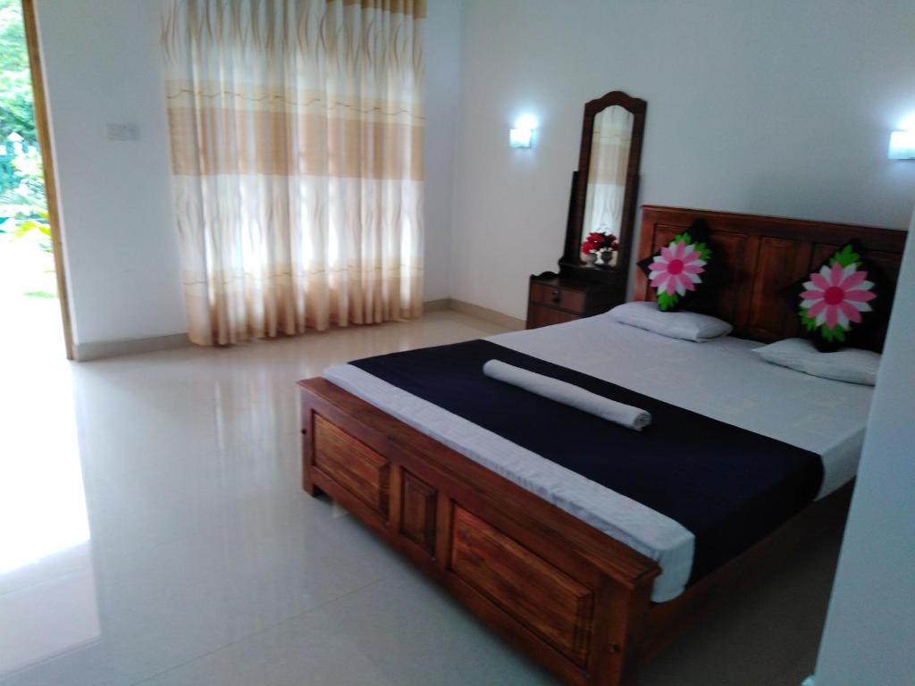 um quarto com uma cama grande e um espelho em Jungle View Guest em Pollonaruva