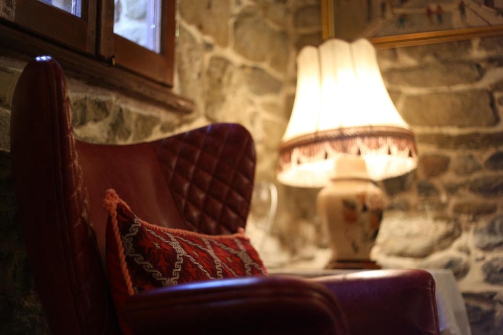 uma lâmpada sentada numa mesa ao lado de uma cadeira em Vila Ebel em Korçë