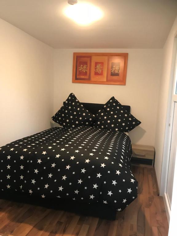 a bedroom with a black comforter with white stars at Casa Ledara Baumberge in Billerbeck