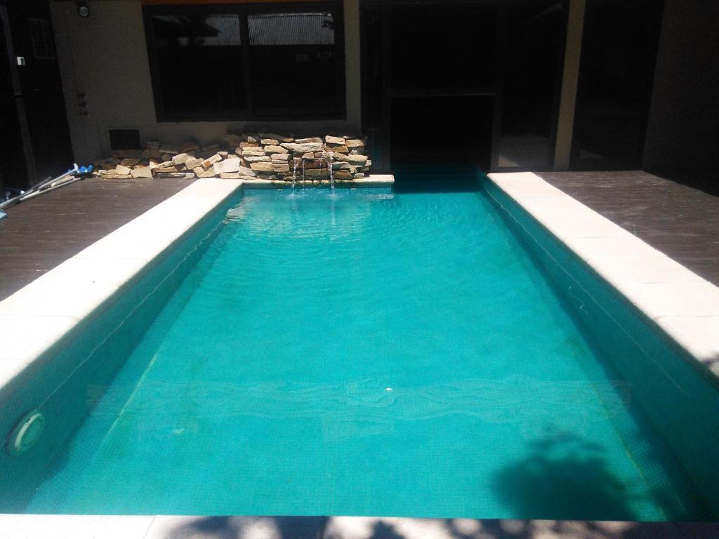 une piscine à l'eau bleue dans un immeuble dans l'établissement Las Golondrinas, à San Martín de los Andes