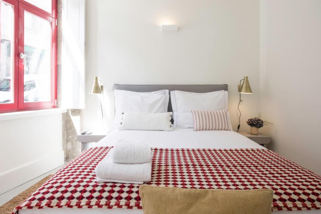 ポルトにあるOporto Sweet Home Iのベッドルーム1室(大型ベッド1台、赤と白の毛布付)