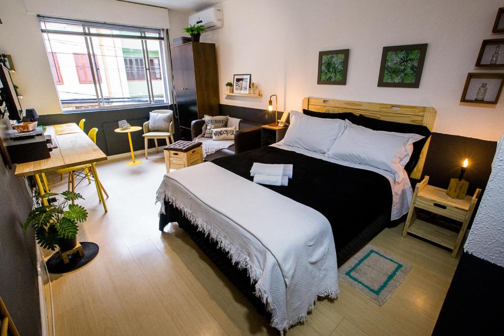 ポルト・アレグレにあるMeu lugar na Cidade Baixaのベッドルーム1室(ベッド1台付)、デスクが備わるベッドルーム1室が備わります。