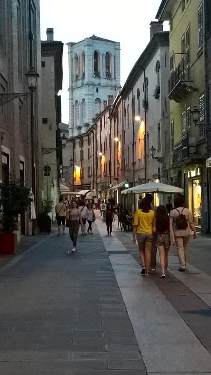 Un gruppo di persone che camminano per una strada cittadina di L'Oro della Città a Ferrara