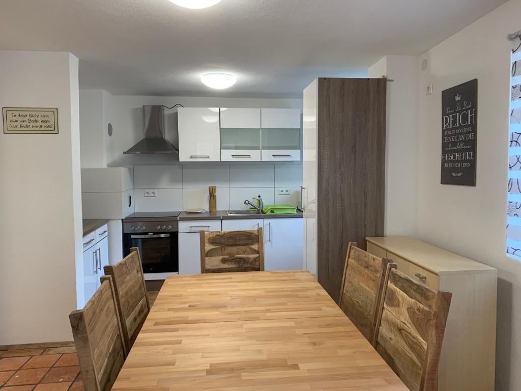 eine Küche mit einem Holztisch und Stühlen in der Unterkunft AB Apartment Objekt 122 in Uhingen