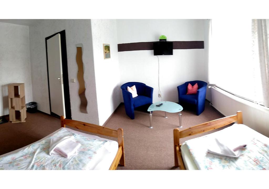 Elsteraue的住宿－Gasthof Zur Eiche，一间设有两张床和两把椅子的房间