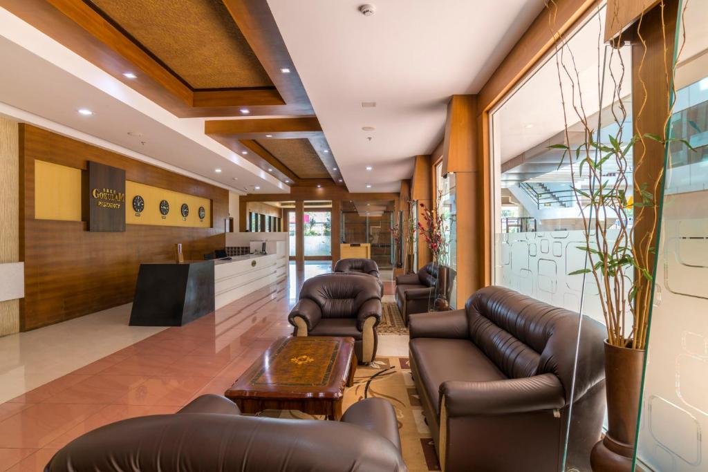 a waiting room with leather couches and a table at Sree Gokulam Residency in Trichūr