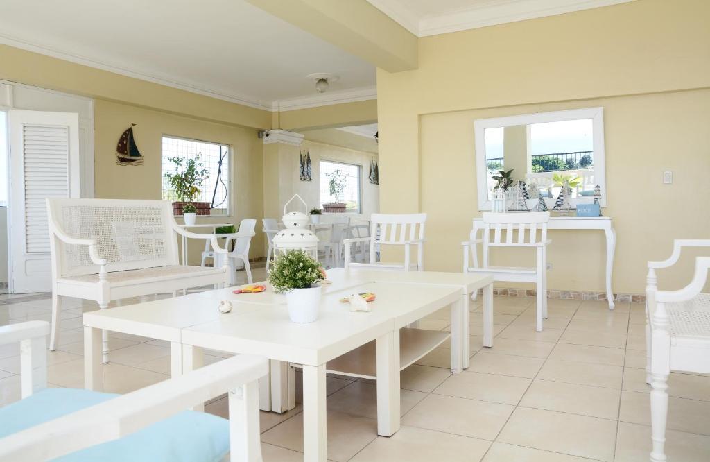 un comedor blanco con sillas y mesas blancas en Hostal Bella Epoca, en Santo Domingo