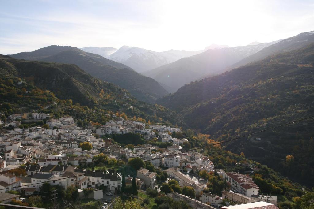 a town in a valley with mountains in the background at estudio mirador in Güéjar-Sierra